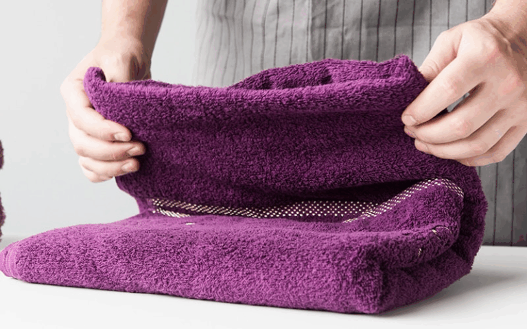 COVER Person folding purple microfiber towel