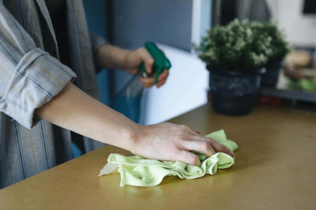 A person cleaning the table with a microfiber cloth. 