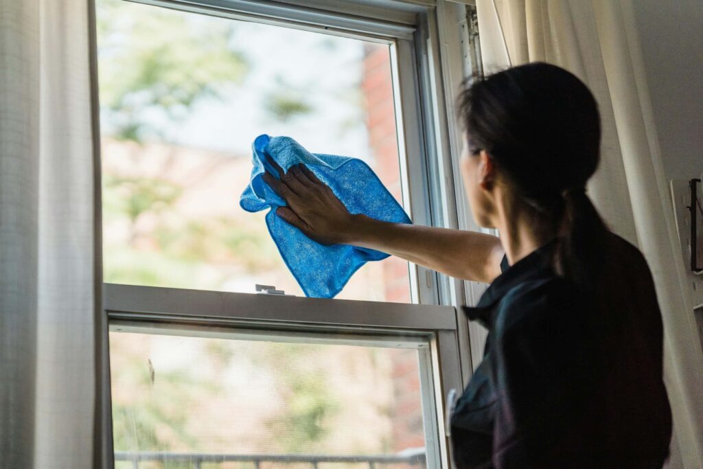 A person wiping the window with a microfiber towel