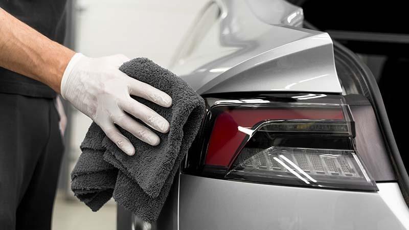 Detailing a grey car with a microfiber towel