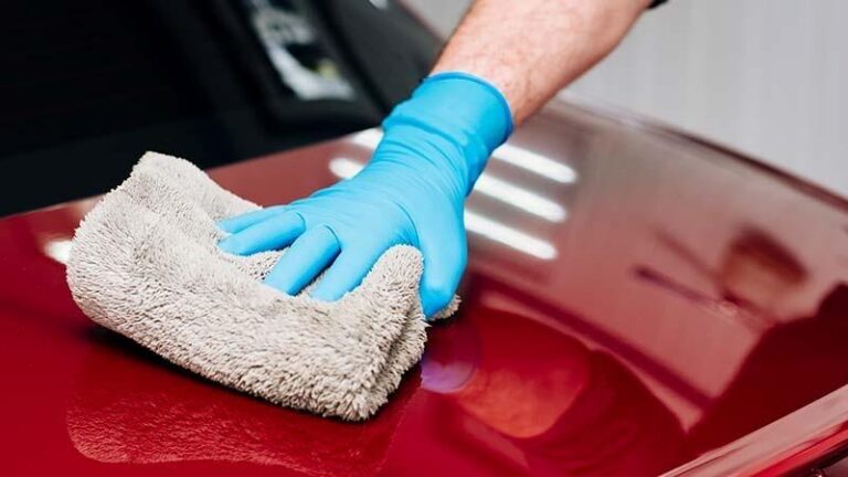 High GSM grey towel on a red car hood