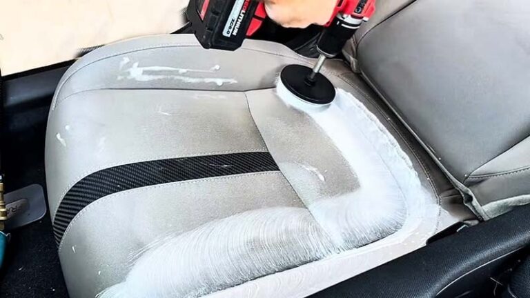 Man using a drill brush to shampoo car seats by Highlands Auto Detailing