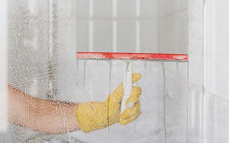 squeegee on soapy shower glass